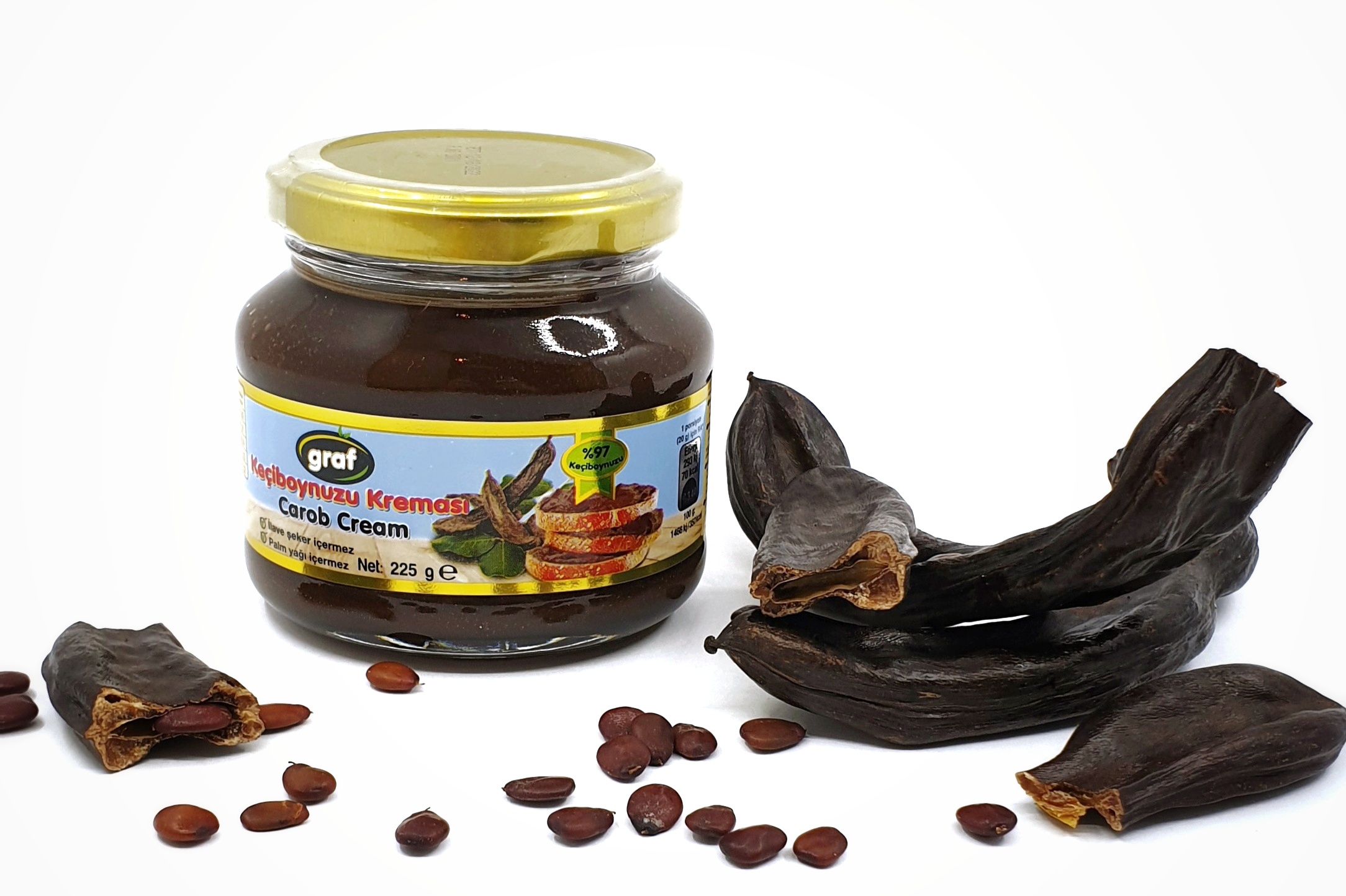 carob cream graf in glass jar next to raw carob with carob seeds