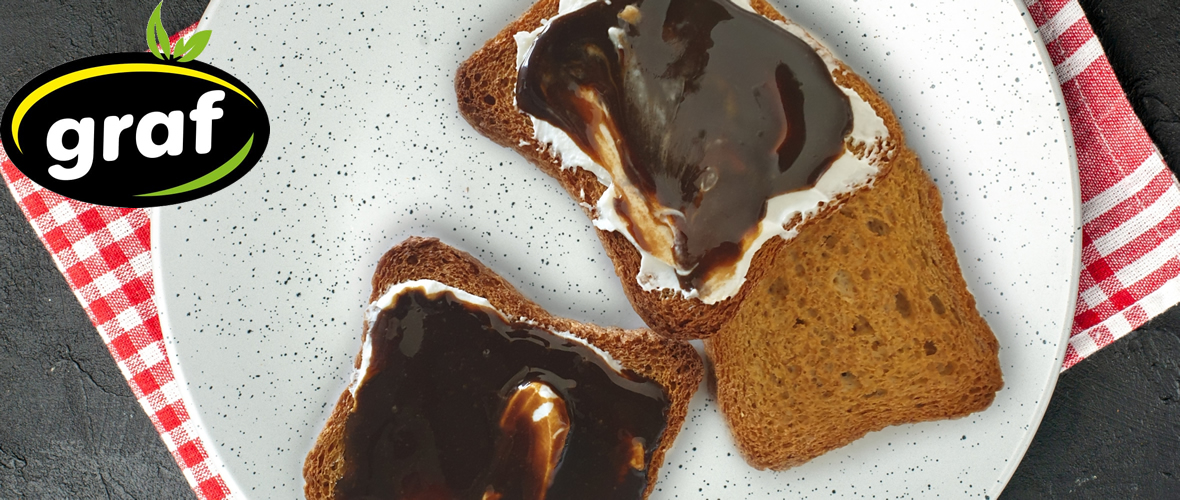 spreaded with carob cream graf and mild cream cheese slices of bread on the white plate